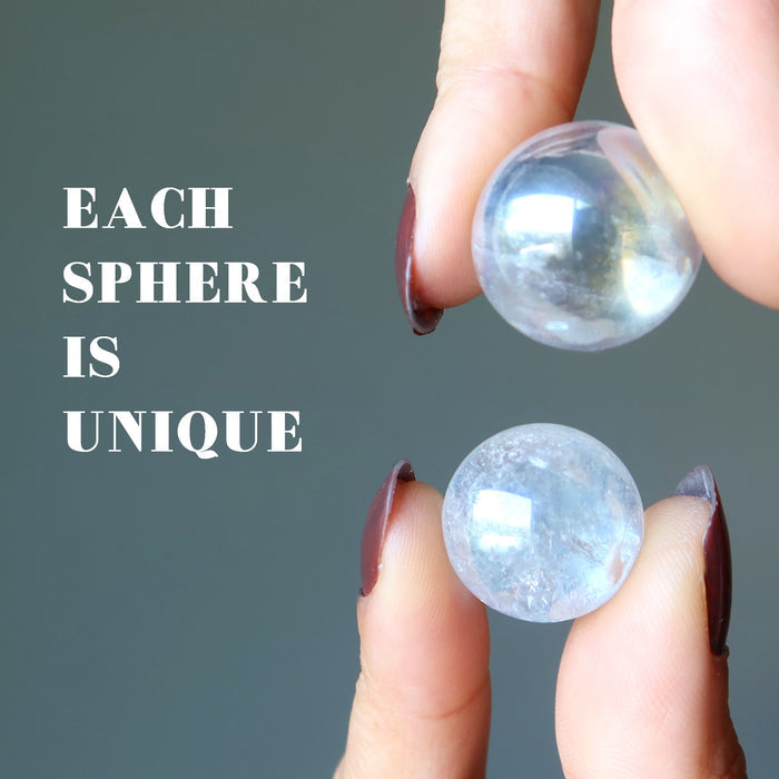 holding an aura quartz ball on each hand