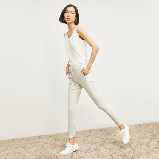 Side image of a woman standing wearing the Curie Pant—Everstretch in Bone | Lead