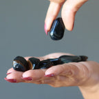 hand holding Hawks Eye Tumbled Stones