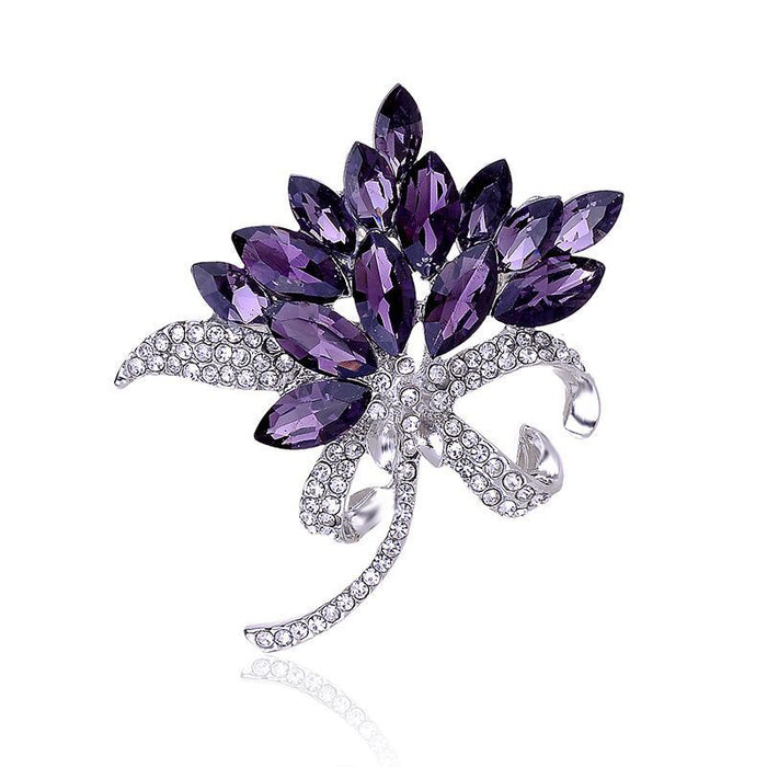 Purple leaf-shaped brooch with clear crystals on a white background